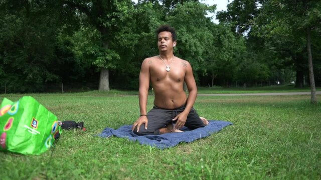 Brown skin  latino guy Doing yoga in a nice afternoon while doing breath work