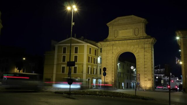 italian town night traffic timelapse - traditional buildings with passing vehicles and pedestrians on the crossroads
