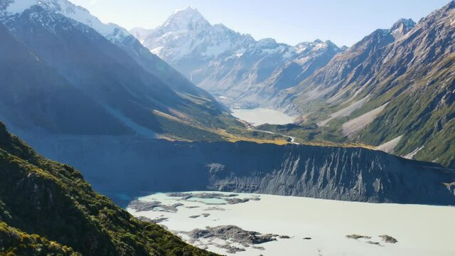 Panorama shot of epic Tasman and Mueller Lake during beautiful sunny day - Snowy peak of Mount Cook in background