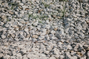 Granite stones behind a metal grate for strengthening the slope. Stones behind the wire. grey texture. construction.