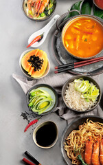 Asian dishes variety on gray background.