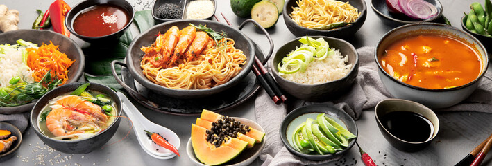 Asian dishes variety on gray background.