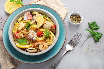 Pasta with seafood on gray background.