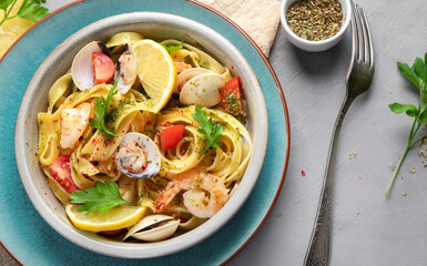 Pasta with seafood on gray background.