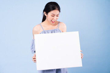 image of asian girl holding white board, isolated on blue background