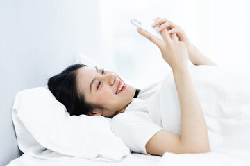Obraz na płótnie Canvas image of girl using phone in bed, in the morning