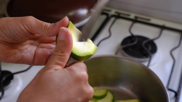 Cutting Fresh Green Squash With Hands Using Kitchen Knife. close up