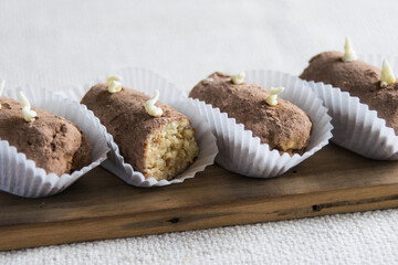 Traditional russian chocolate potato cake on a wooden board on linen tablecloth. Horisontal, selective focus