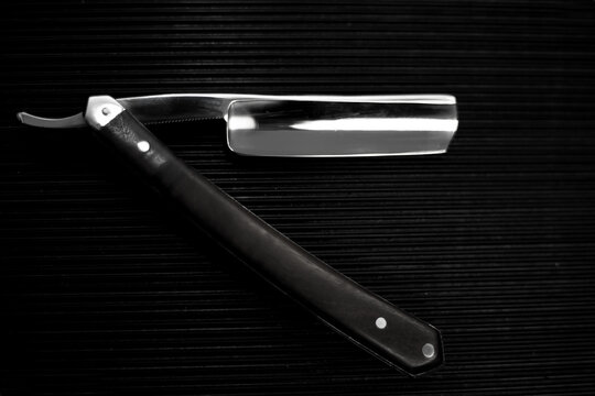 barber tool straight razor close in retro vintage style. Black and white picture
