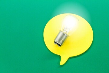 a conversation box with a brightly lit bulb. noise. concepts of ideas and questions