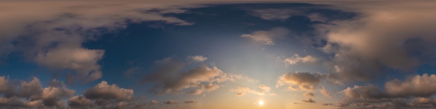 Blue evening sky seamless panorama spherical equirectangular 360 degree view with Cumulus clouds, setting sun. Full zenith for use in 3D graphics, game and aerial drone panoramas as sky replacement.