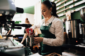Caucasian female barista at work making coffee