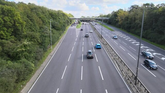  Cars driving on multilane trunk road and stopping to queue on exit ramp.