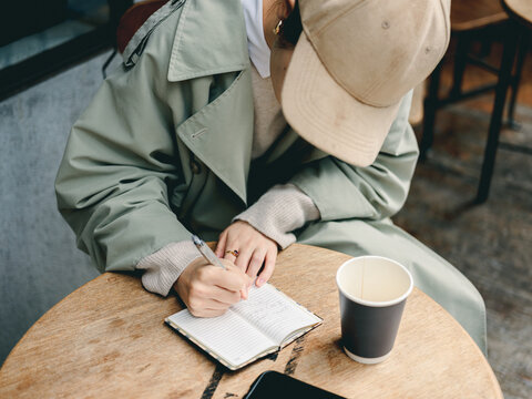 帽子を被り文字を書く女性