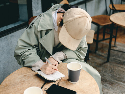 帽子を被り文字を書く女性