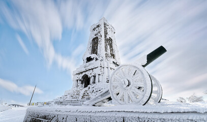 Shipka Monument (Monument of The Liberty) is a monumental construction, located at Shipka peak in Stara Planina mountain, near town of Shipka, Bulgaria at winter. artillery gun covered with snow