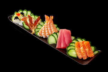Sashimi set with raw salmon, tuna, grilled unagi eel, cuttlefish and tobiko on black background
