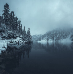 Moody misty alpine lake with fresh autumn snow in Washington