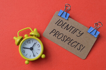 Clock and brown card with text IDENTIFY PROSPECTS!