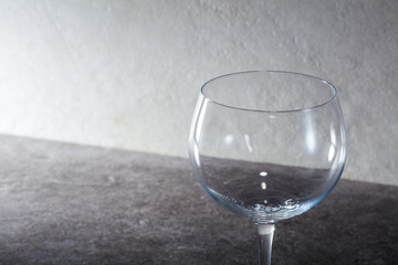 Empty red wine glass placed in front of marble tile background