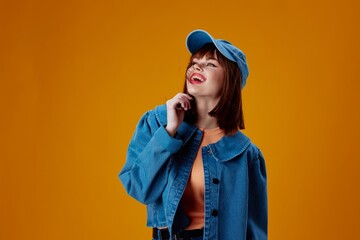 Pretty young female denim cap red lips glamor fashion yellow background unaltered
