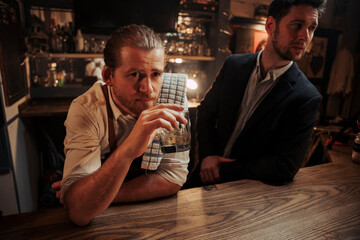 Caucasian male customer having a drink with manager at the bar 