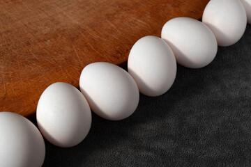 raw beautiful chicken eggs on wooden board