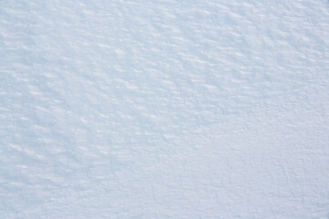 Natural snow texture. Smooth surface of clean fresh snow. Snowy ground. Winter background with snow patterns. Perfect for Christmas and New Year design. Closeup top view.