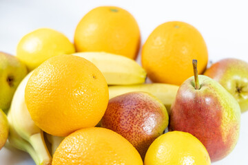 Healthy fresh fruits and bright colors, light background, fruits with lots of vitamins. Bananas, orange and pears. Close-up. Side view