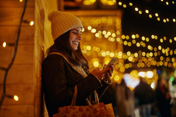 Woman using cellphone during Christmastime in the city