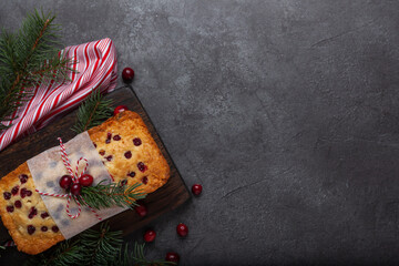 Christmas spicy cake with berries, decorated with cranberries on the black background top view horizontal format. Christmas Background for invitations, greeting card, postcard. Recipe tasty homemade
