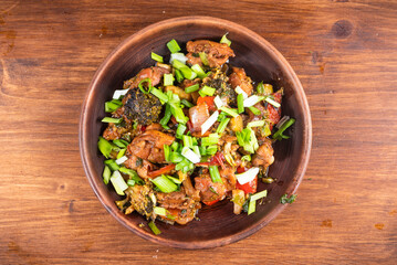 Fried chicken with vegetables in a plate on the table, top view
