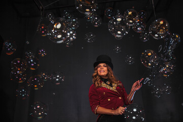 Female magician makes with soap bubbles show, an illusionist