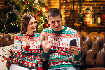 Family congratulates friends Merry Christmas on video communication. Couple sharing good news with friends and family on video chat during self isolation. Virtual celebration with friends video call