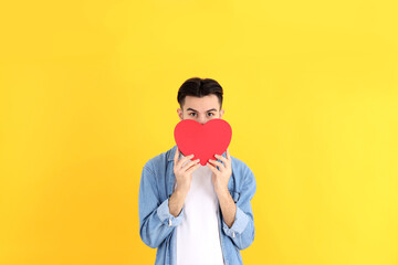 Attractive guy with heart on yellow background