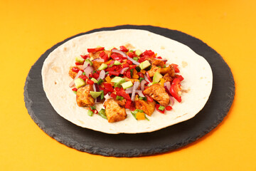 Tasty taco on board on orange background