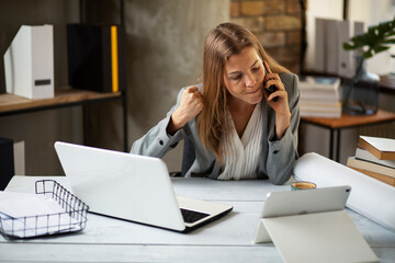 Girl at work, using her phone. Secretary answering calls. Manager at the office desk..