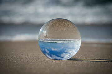 Fototapeta na wymiar Glass globe on the beach of the Baltic Sea in Zingst in which the landscape is depicted.