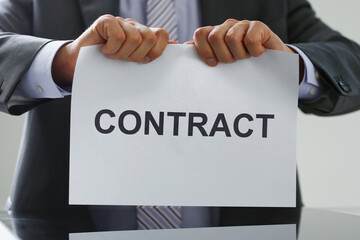 Male worker in costume and tie tear contract paper apart, end of business offer
