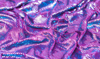 Fototapeta na wymiar Fabric with sequins as a background. Glittery texture is the trend of the season. Sparkling color holographic blue, pink.