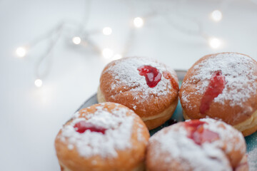 Sufganiyot donuts with icing sugar and red jelly. Israeli jelly donuts for Hanukkah