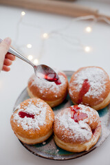 Sufganiyot donuts with icing sugar and red jelly. Israeli jelly donuts for Hanukkah