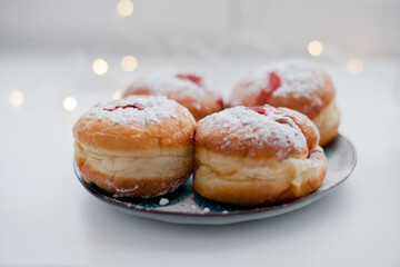 Sufganiyot donuts with icing sugar and red jelly. Israeli jelly donuts for Hanukkah