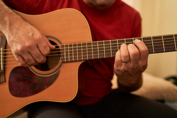 detail of a man playing acoustic guitar