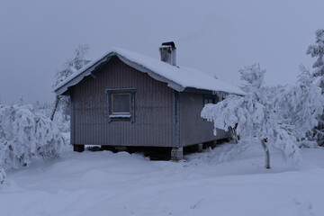 A cozy small log cabin covered in snow in winter landscapes in Northern Sweden, Nordic
