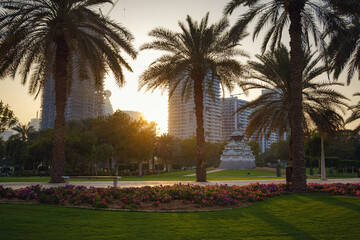 Alley with green lawn and trees in the Zabeel park, Dubai, UAE. View of the modern Dubai skyline from the approach highway to the Zabeel Palace, Dubai, United Arab Emirates