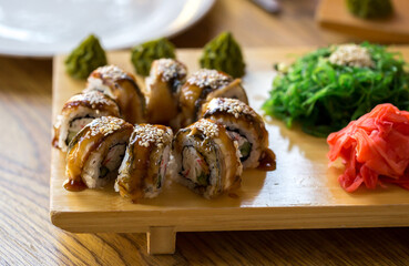 Sushi rolls Japanese delicacies. Japanese traditional rice and fish dishes. Beautiful serving food on a dark background with copy space. A set of delicious goodies.