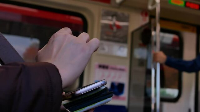 The motion of commuter taking MRT and playing phone in Taipei Taiwan with 4k resolution.