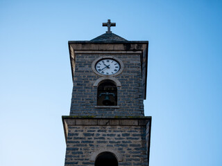 front view of the facade of a tower with bell tower and clock