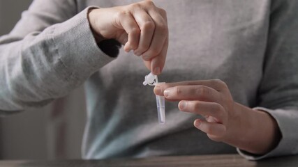 medicine, quarantine and pandemic concept - woman taking sample from her nose with swab and making self testing nasal coronavirus test at home